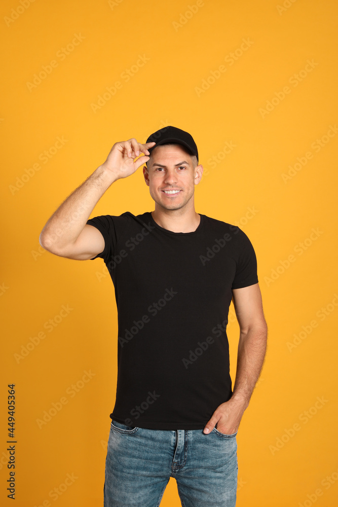 Happy man in black cap and tshirt on yellow background. Mockup for design Happy man in black cap and tshirt on yellow background. Mockup for design