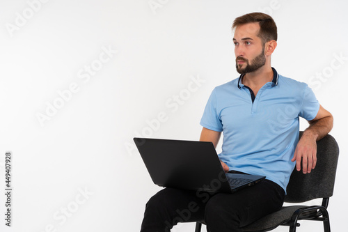 Guy is sitting with a lapto...