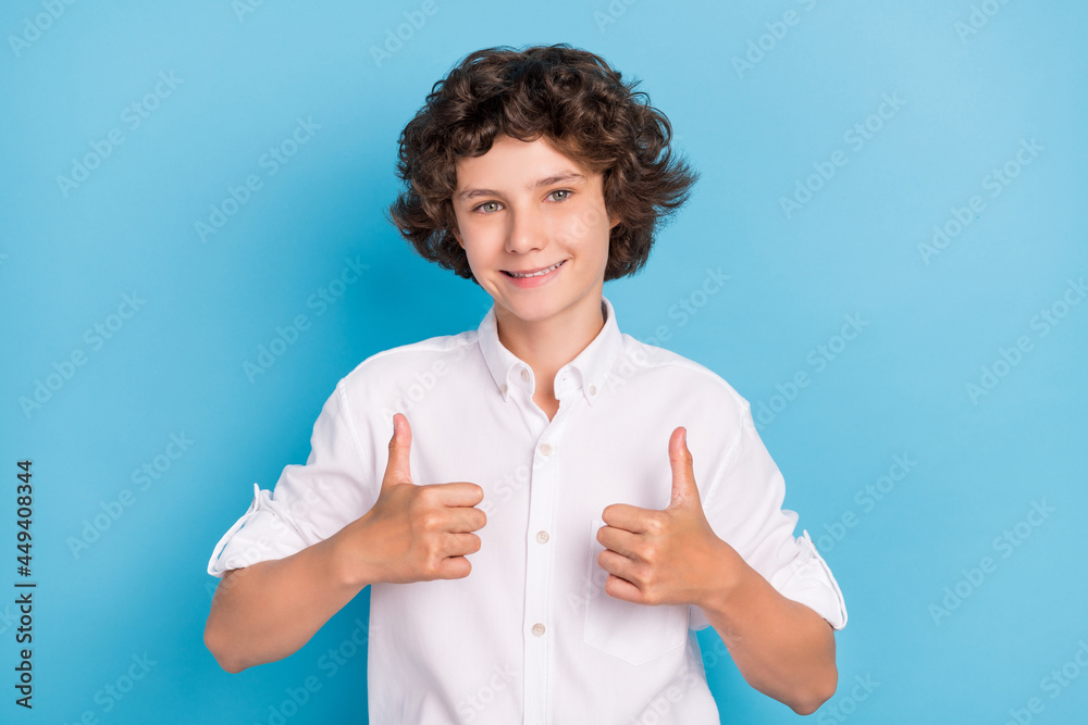 Photo of funky attractive schoolboy wear white shirt smiling showing thumbs up isolated blue color background Photo of funky attractive schoolboy wear white shirt smiling showing thumbs up isolated blue color background