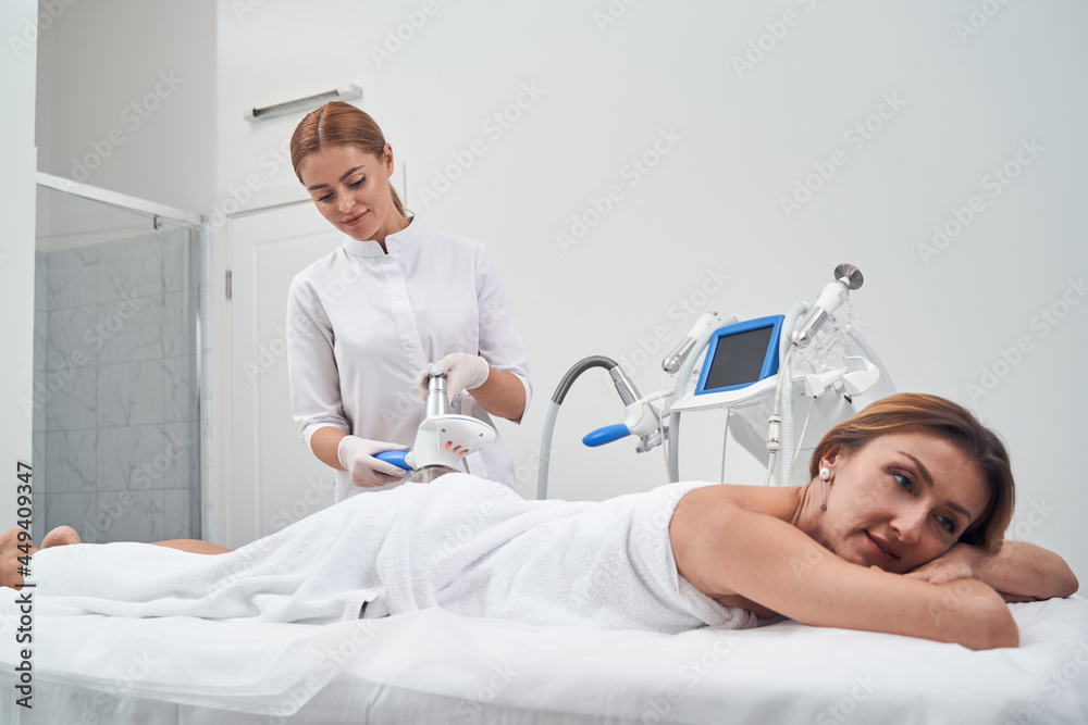 Obraz premium Happy lady enjoying massage in beauty studio