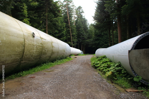 Mast eines alten Windrades lagert im Wald auf den Abtransport photo