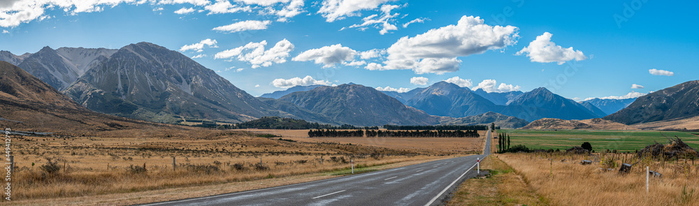 Road through fields and mountains in New Zealand