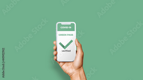 Hand holding a phone with Green Pass verification for covid-19 photo