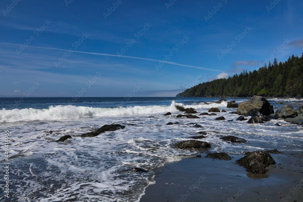 Mystic Beach shoreline with blue sky, trees, rocks and surf.  Iconic scene from the west coast of Vancouver Island, British Columbia, Canada. 