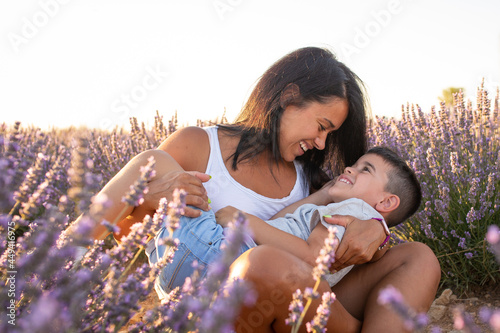 young latina woman plays with her son in a field of lavender flowers. Enjoying family life in nature