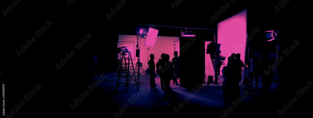 Silhouette images of film production. behind the scenes or b-roll of making video commercial movie. Film crew lightman and cameraman working together with film director in studio. Film industry. - obrazy, fototapety, plakaty 