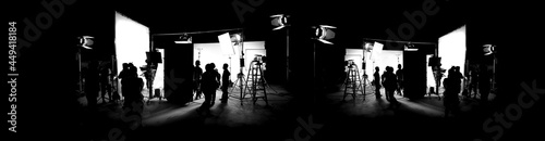 Silhouette images of film production. behind the scenes or b-roll of making video commercial movie. Film crew lightman and cameraman working together with film director in studio. Film industry. photo