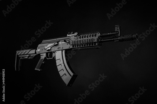 A pneumatic copy of a Russian machine gun. Modern airsoft weapons. Dark background with red illumination.