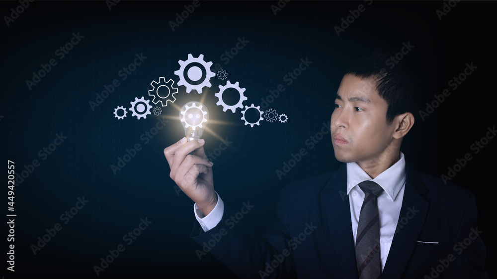 Businessman holding light bulb with a gear icon. The idea of inspiration online technology. innovation idea concept. Businessman holding light bulb with a gear icon. The idea of inspiration online technology. innovation idea concept.