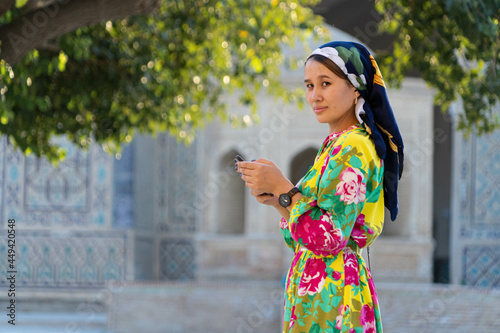 Muslim girl with a scarf on her head at the gate of the old mosque. Bukhara, Uzbekistan. photo