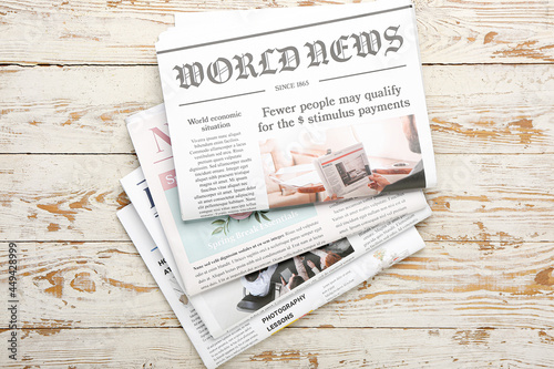 Newspapers on light wooden ...