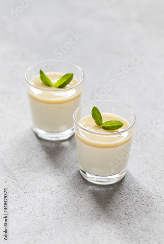 Creamy pudding gooseberry with sauce in a glass on a light gray background