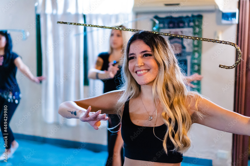 young hispanic latin woman dancing arabic dance with stick. smiling young hispanic latin woman dancing arabic dance with stick. smiling