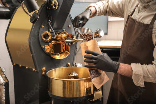 Slika na platnu Man packaging coffee beans after roasting