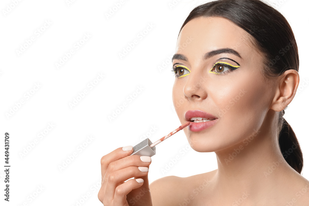 Beautiful young woman applying lipstick on white background Beautiful young woman applying lipstick on white background