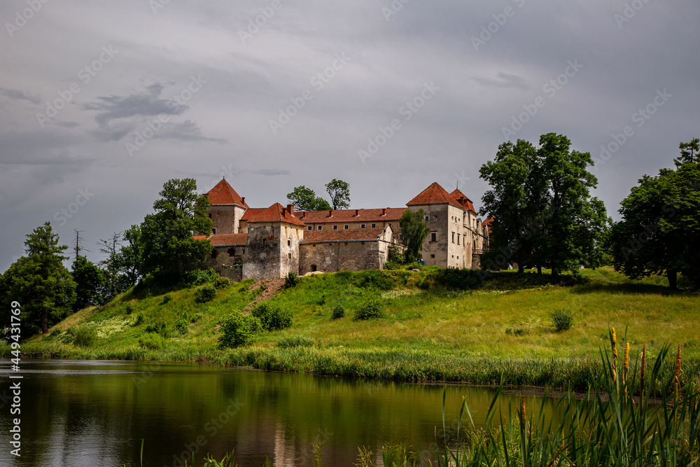 Beautiful panorama of Svirzh castle by the river on a summer day, near Lviv.