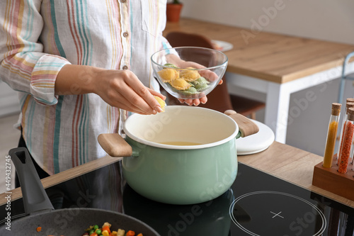 Woman cooking tasty ravioli in kitchen
