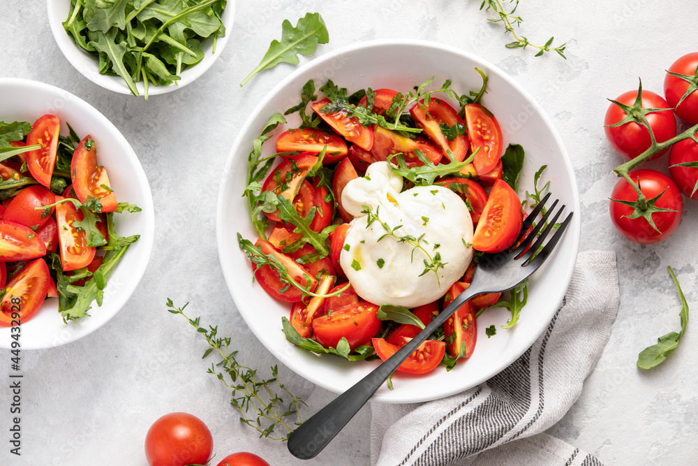 Burrata arugula salad with ripe summer tomatoes and olive oil