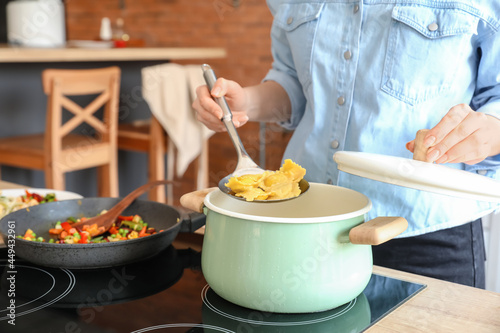 Woman cooking tasty ravioli in kitchen