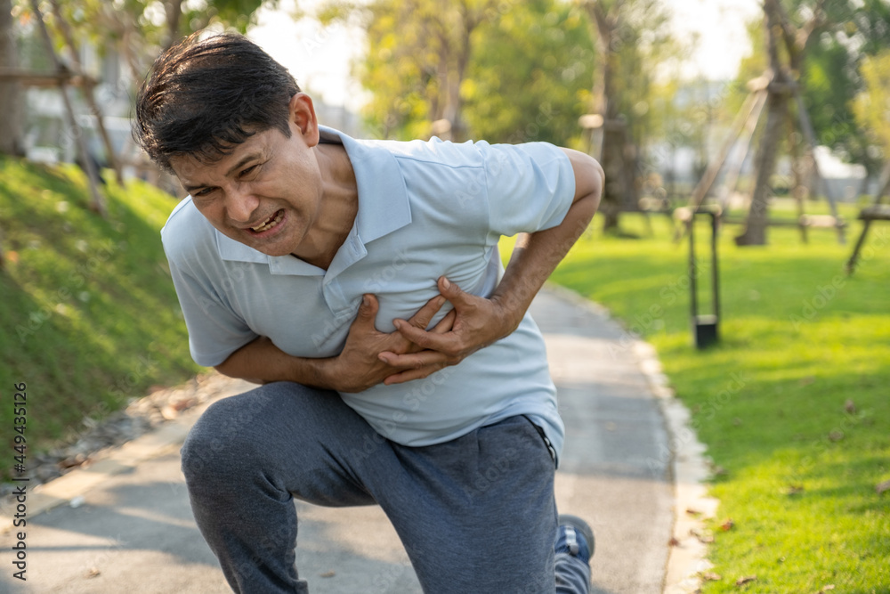 Senior man holding his chest and feeling pain suffering from a heart attack while running at the outdoor park. Senior man holding his chest and feeling pain suffering from a heart attack while running at the outdoor park.