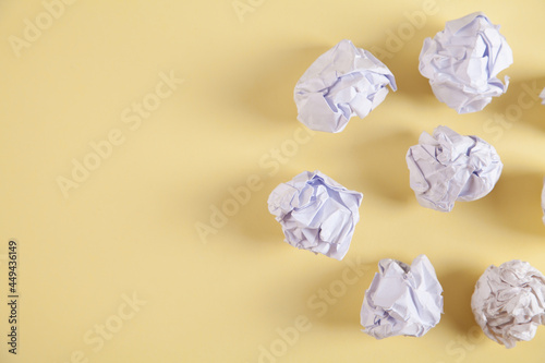 Set of crumpled paper balls, on an isolated yellow background. © ANAHIT