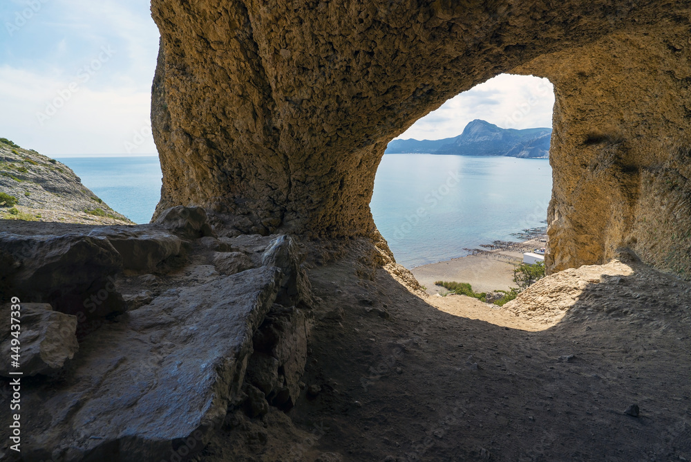 Sea view from a small cave on the slope of the coastal mountain Aeolian harp. Cape Alchak, Sudak, Crimea.