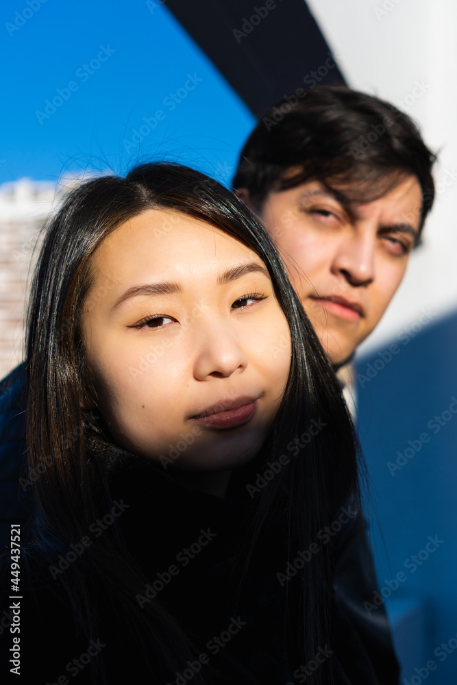 vertical photo of asian american woman with her interracial partner, latino man sky background, sunrise, sunlight vertical photo of asian american woman with her interracial partner, latino man sky background, sunrise, sunlight