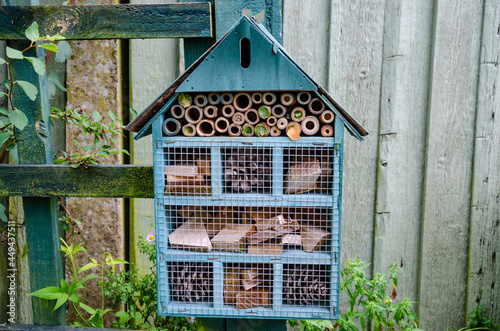 A bee or insect hotel attached to a post in a garden to provide insects with a safe place to hibernate.