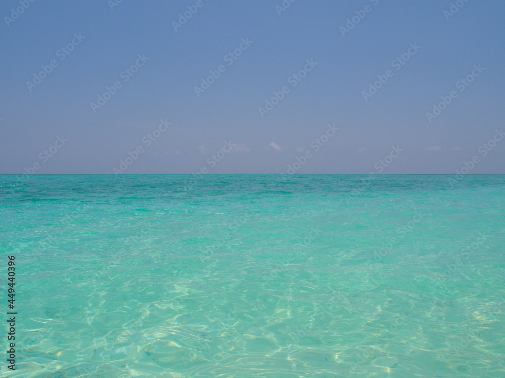 Blue water and blue sky on the horizon of the Indian Ocean in the Maldives. Copy space for text.