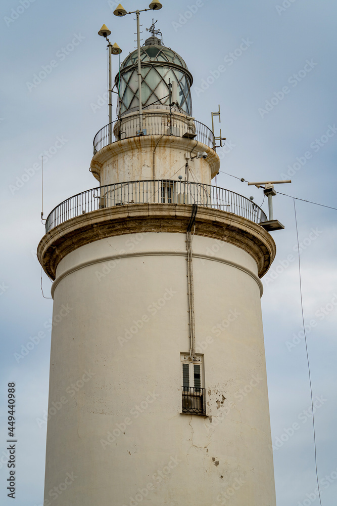 White lighthouse in the center of Malaga in southern Andalusia, Spain, during a sunny summer day at sunset