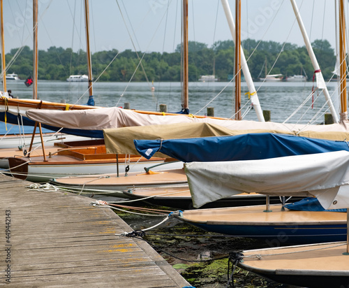 Sailing boats moored along the wooden staging on the side of Wroxham Broad during the annual sailing regatta open week.