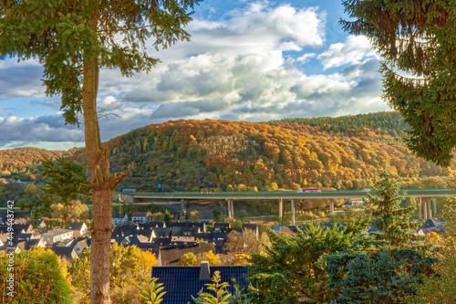 Sunny autumn - colorful forest hills with a highway in the background