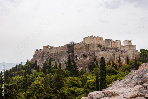 Acropolis hill  Parthenon  Propylaea  Temple of Athena Nike  Hekatompedon Temple  in greenery  Athens ancient historical landmark in city center with rocky Areopagus - Hill on cloudy day