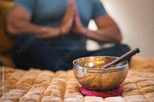 Tibetan singing bowl with man praying in background