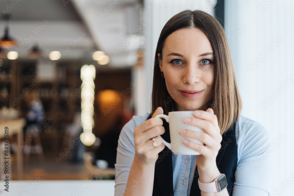 Attractive female with cute smile having a coffee while relaxin in a break Attractive female with cute smile having a coffee while relaxin in a break