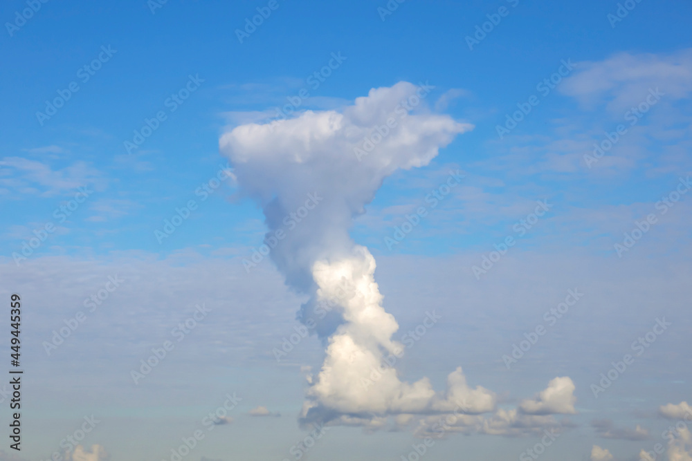 Obraz premium Background image: a large vertical cloud high in the blue sky