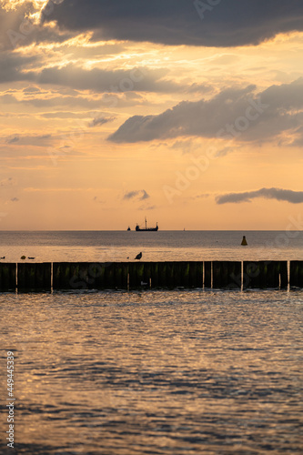 ship sails through the sea against the setting sun