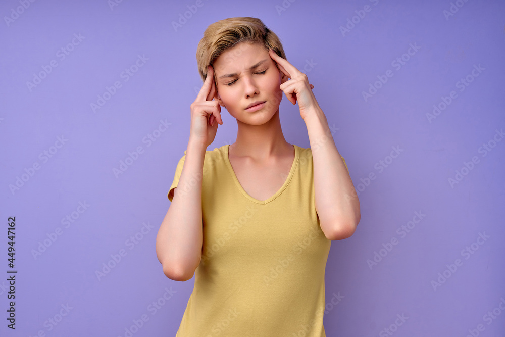 Young Adult Female Suffering From Headache, Touching Head, Having Pain, wondering, headache with anxious, not happy, beautiful woman in casual outfit with short hair on purple background, copy space Young Adult Female Suffering From Headache, Touching Head, Having Pain, wondering, headache with anxious, not happy, beautiful woman in casual outfit with short hair on purple background, copy space