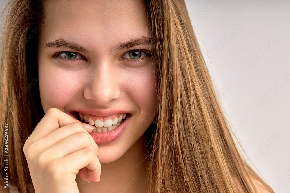 flirtatious girl with natural long brown hair looking at camera and smiling, close-up portrait. young female having no make-up, perfect skin. natural beauty, human emotions concept, copy space flirtatious girl with natural long brown hair looking at camera and smiling, close-up portrait. young female having no make-up, perfect skin. natural beauty, human emotions concept, copy space