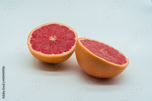 Two half juicy and delicious grapefruits on white background