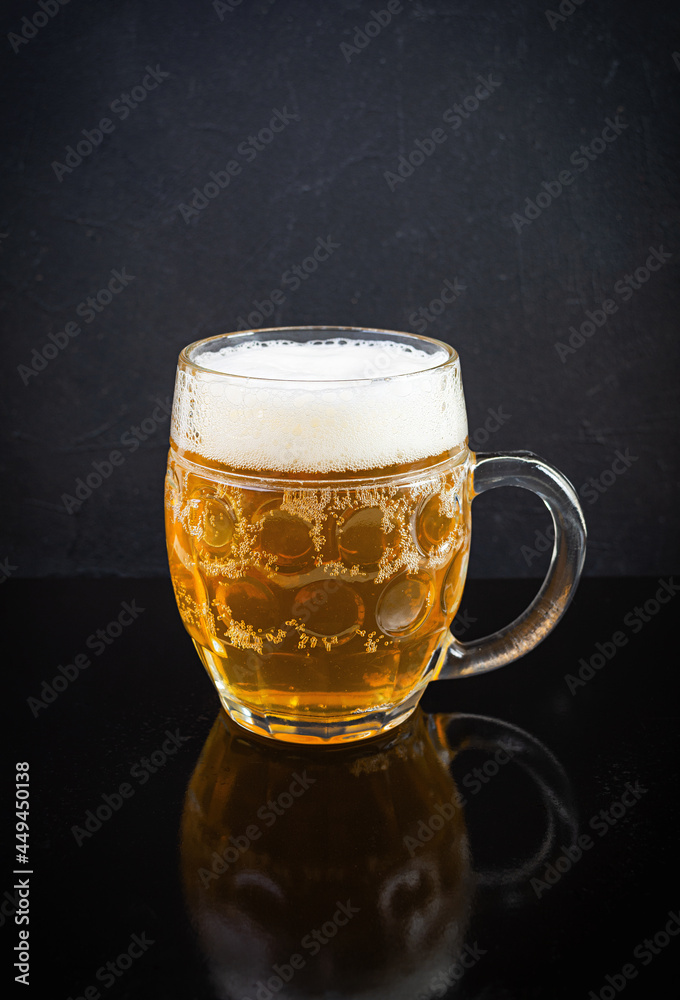 Mug of light beer on dark background. Craft unfiltered beer Mug of light beer on dark background. Craft unfiltered beer