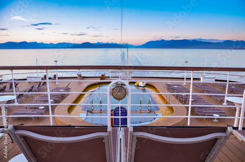 Aft View of cruise ship pool and mountains at dusk