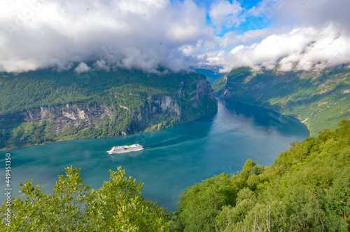 Cruise ship sailing through a Norwegian fjord in Geiranger.