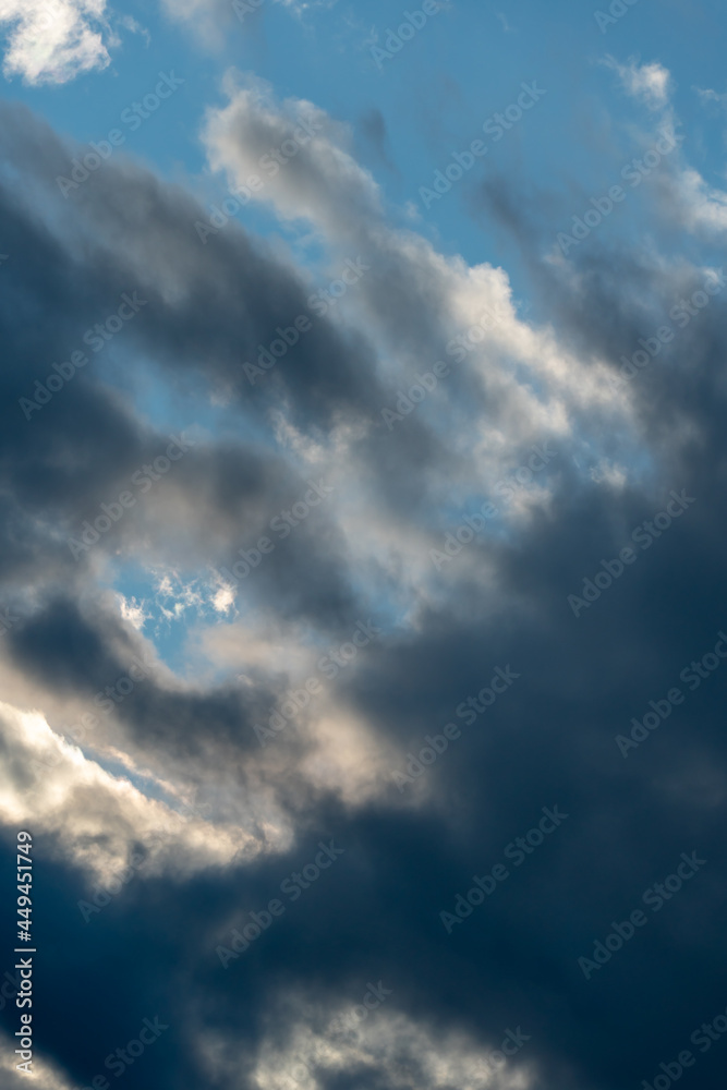 Fototapeta premium Beautiful fluffy clouds in the evening sky. The sunlight gives a side light on the clouds. Clouds before rain.