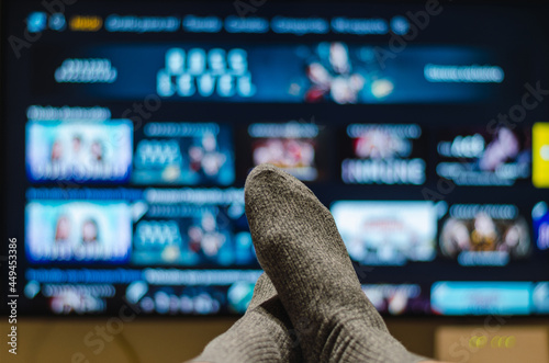 Cropped feet of man who is watching smart tv in living room