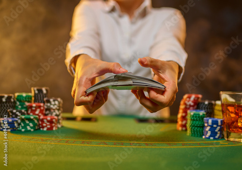 Canvas Print The girl croupier holds poker cards in her hands