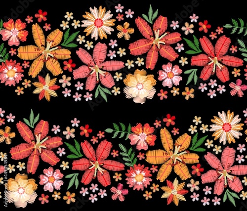 Wide stripes of embroidered flowers on a black background. Large red and orange lilies among tiny flowers. Satin stitch embroidery. Vector seamless pattern.
