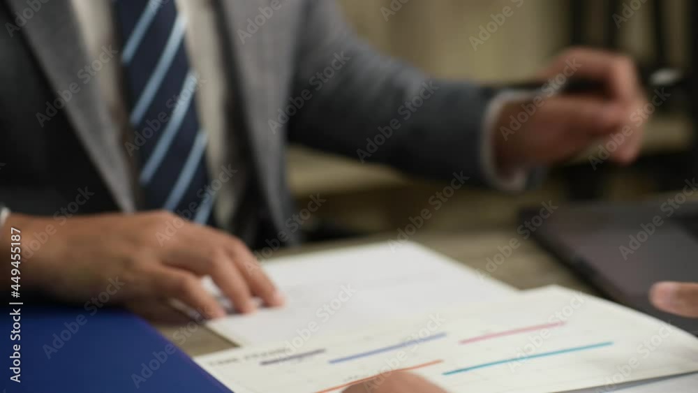 Finger of business man point to Project schedule work processes and brainstorm meeting to colleagues in modern office, business people working together by explaining time line document paper to team. Finger of business man point to Project schedule work processes and brainstorm meeting to colleagues in modern office, business people working together by explaining time line document paper to team.