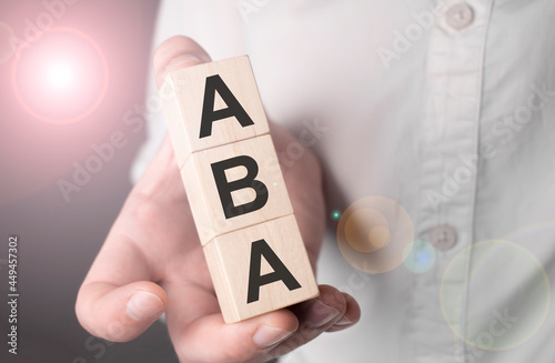 Man holding ABA word on wooden cube. photo