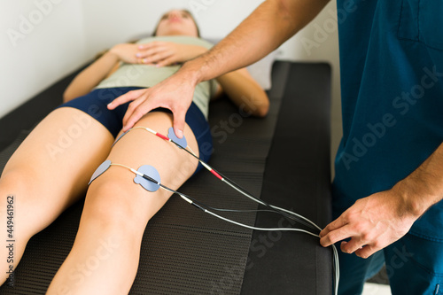 Male physiotherapist treating a patient photo